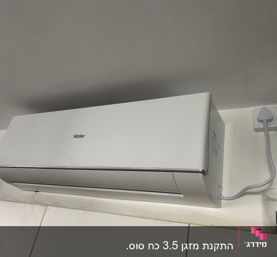 מזגן קיר לבן מחובר לשקע חשמל